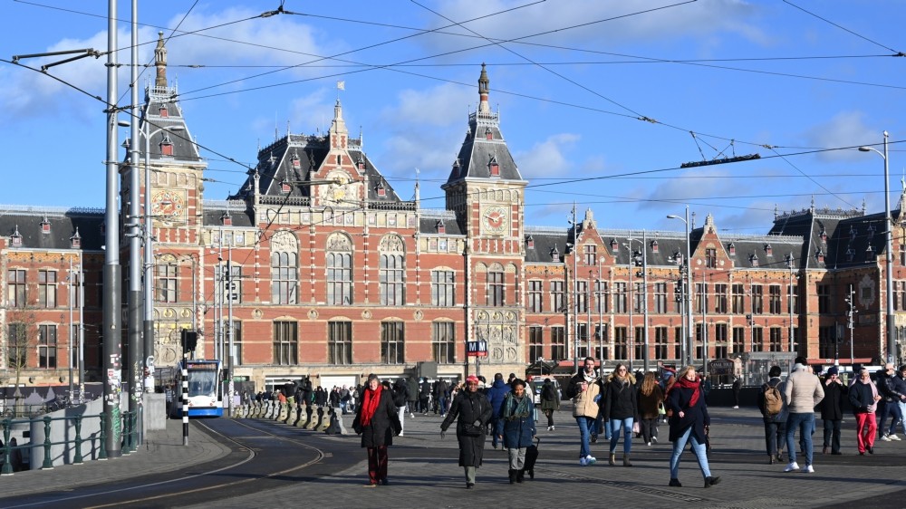 Voorzijde van Amsterdam Centraal Station met voetgangers